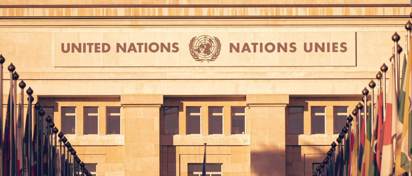 The United Nations building in afternoon sunlight with country flags in the foreground - UNSPLASH The United Nations building in afternoon sunlight with country flags in the foreground